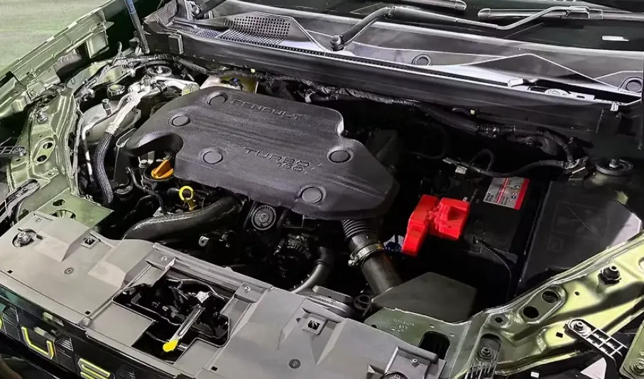 2026 रेनॉल्ट डस्टर का इंजन बे, जिसमें टर्बो पेट्रोल इंजन, बैटरी और इंजन कवर साफ दिखाई दे रहे हैं
